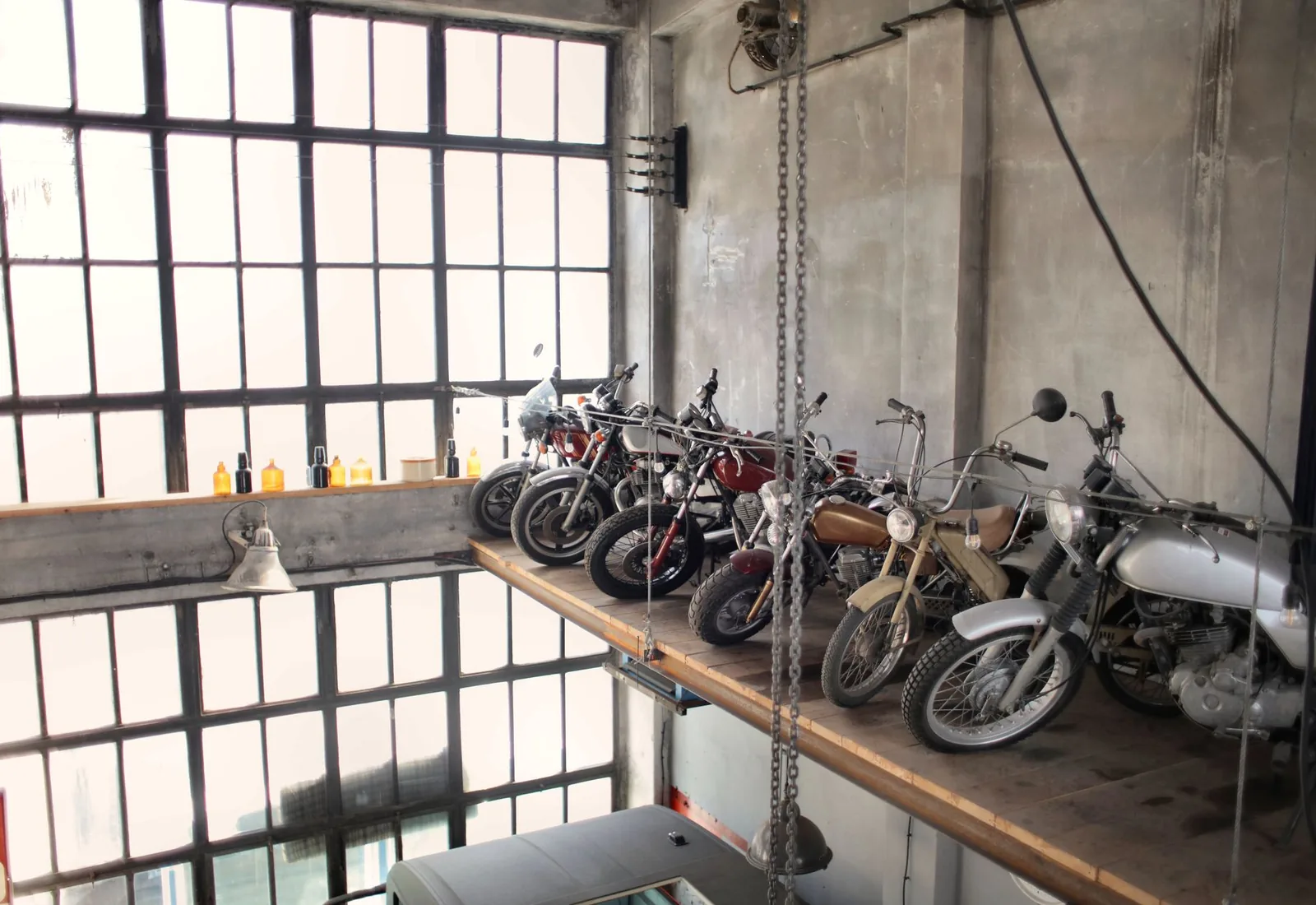 Atelier où sont alignés plusieurs VéloSolex et cyclomoteurs anciens