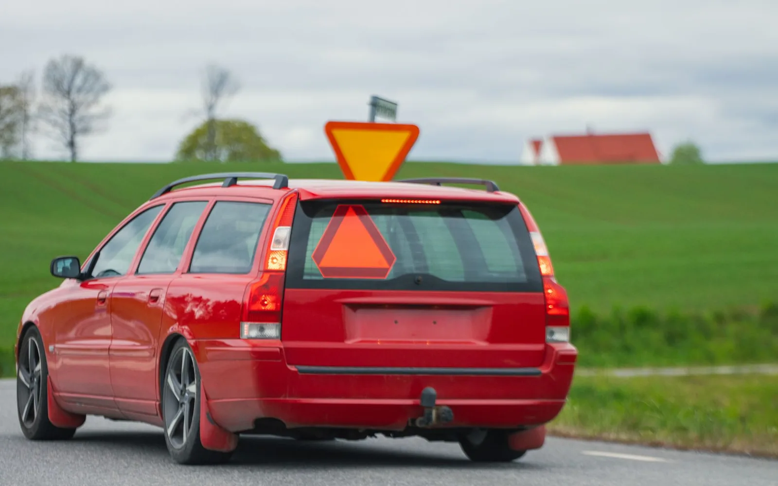 Arrière d’une voiture équipée d’un attelage, sur une route de campagne