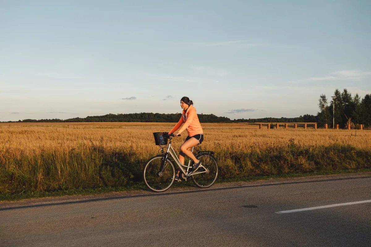 Cycliste de profil sur une petite route de campagne