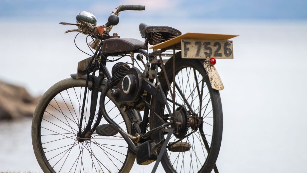 Vieux vélo à moteur auxiliaire avec plaque ancienne