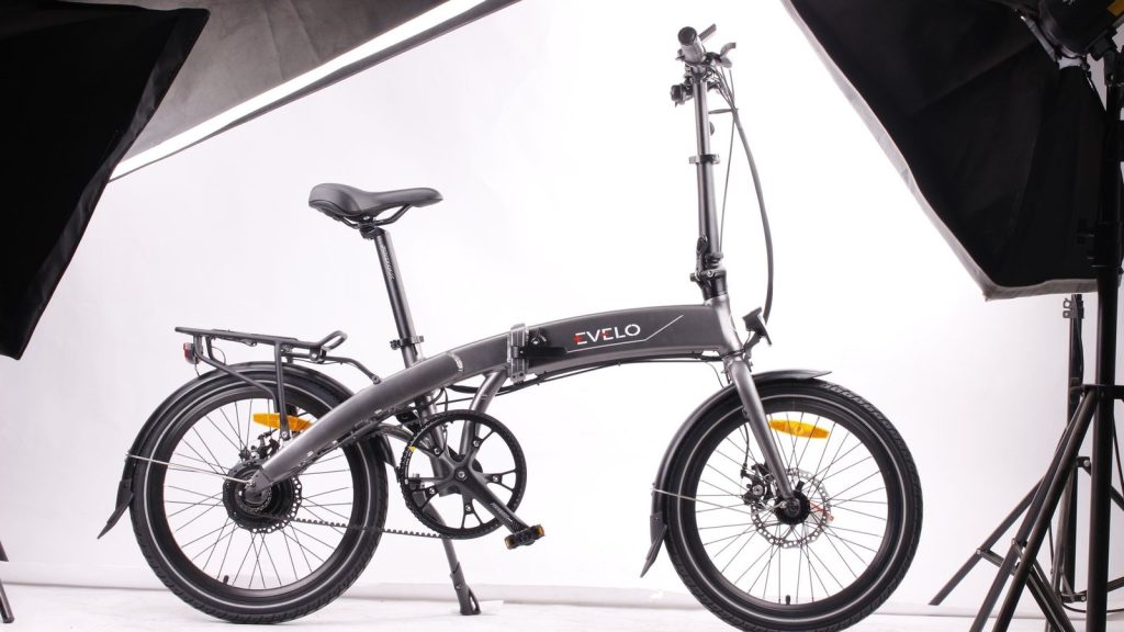 Vélo électrique pliant gris sur fond de studio blanc
