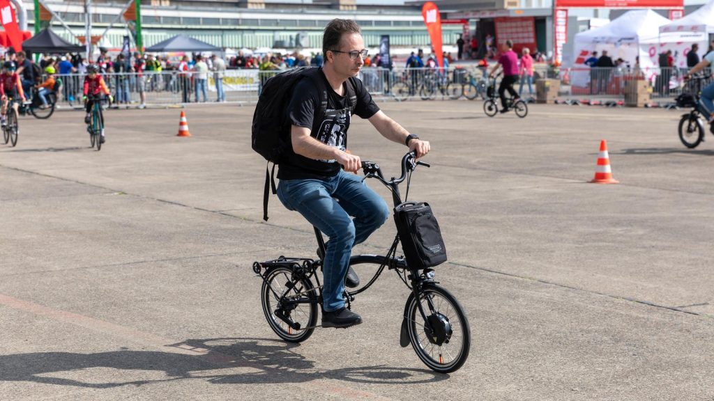 Homme à vélo pliant à assistance électrique lors d'un rassemblement de cyclistes