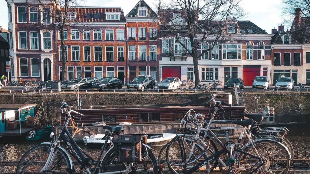 Vélos garés devant des maisons à pignons au bord d'un canal néerlandais