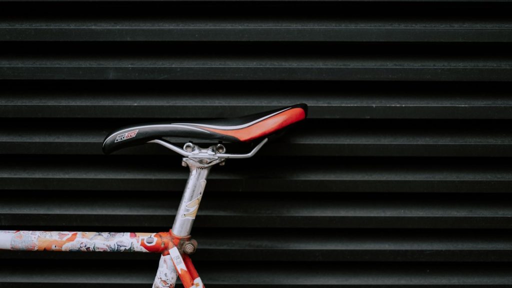 Cadre de vélo à la peinture écaillée devant un rideau métallique noir